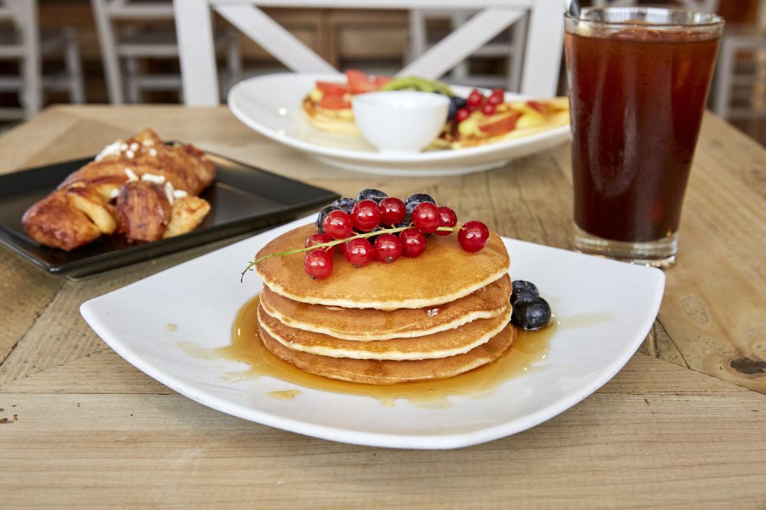 Pancake con frutti rossi e brioche sul tavolo