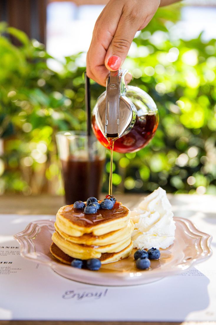 Pancake con frutti di bosco e sciroppo d'acero versato al momento